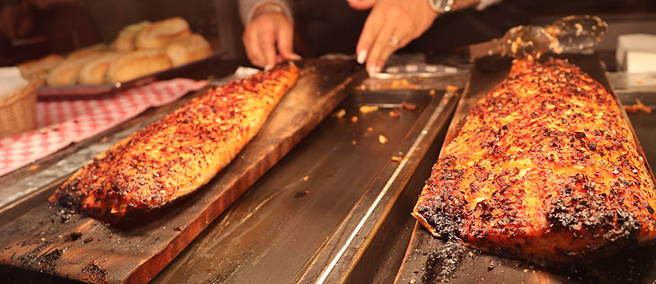 Hamburgs Fischhütt'n auf dem Oktoberfest 2024. Die Spezialität:  Flammlachs an Buchenholzfeuer gegart (©Foto:Martin Schmitz)